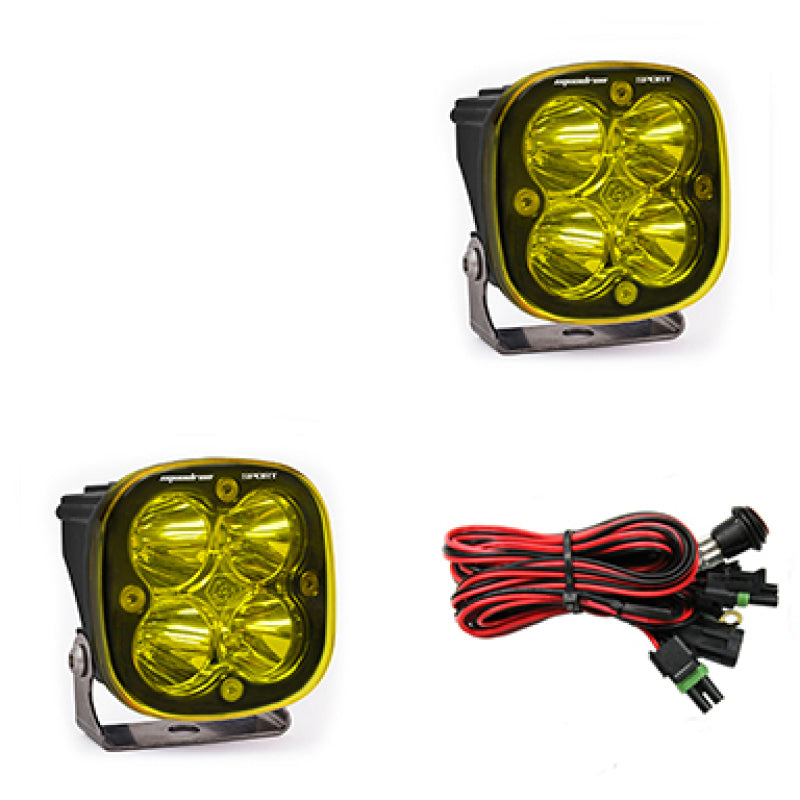 Baja Designs Squadron Sport Spot LED light pods in amber with mounting brackets and wiring harness for offroad vehicles.