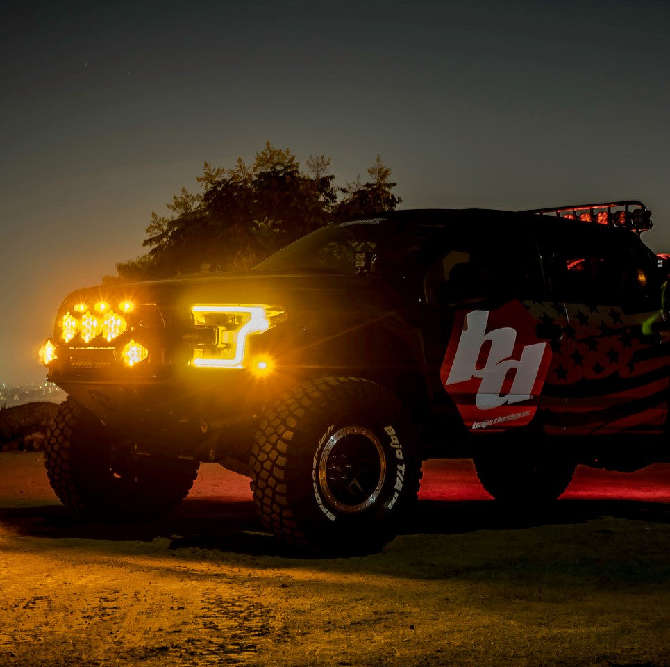 Baja Designs LP6 Pro amber driving lights mounted on a truck, illuminating the night with a vibrant glow.